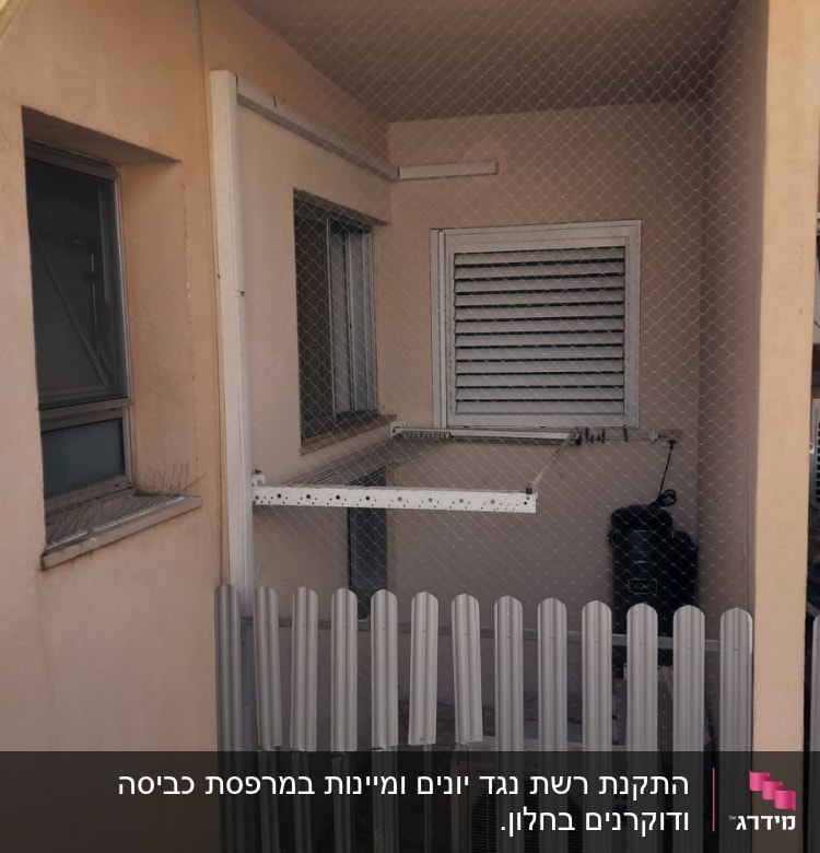 רשת נגד יונים מותקנת במרפסת קטנה עם חלון